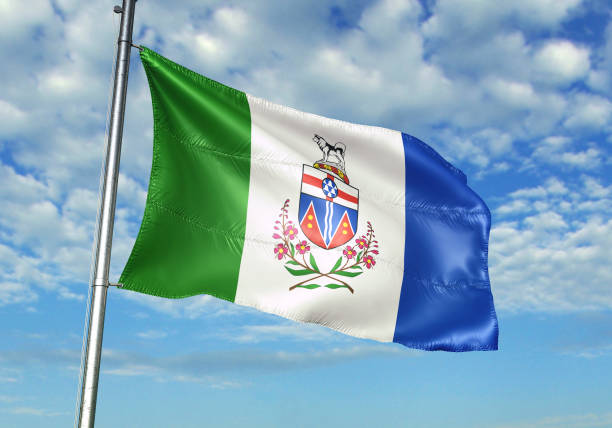 bandera de yukón de canadá ondeando con el cielo sobre el fondo - yukon fotografías e imágenes de stock