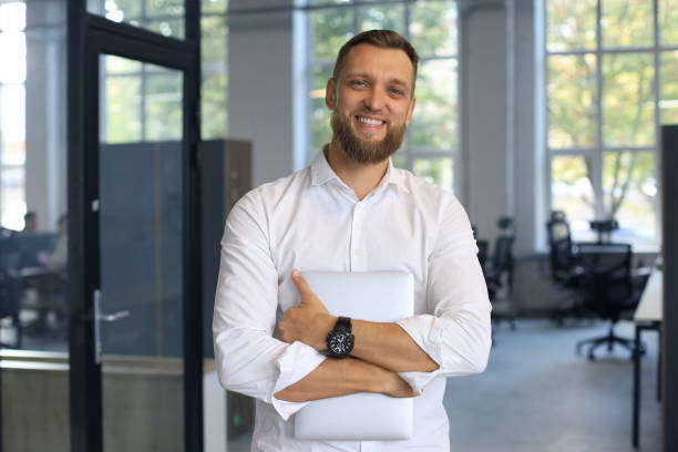 istock Young handsome businessman smiling in an office environment 1269486176