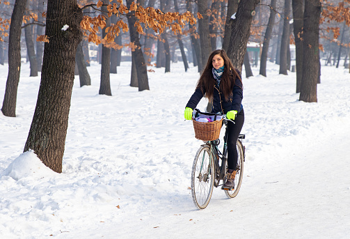 Young lady going to her workplace by bicycle in wintertime