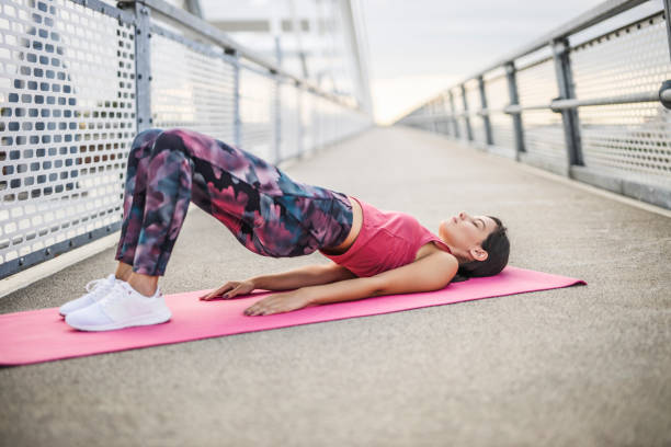 요가를 연습하는 젊은 스포티 한 여성, dvi pada pithasana 운동을하고, 둔부 다리 포즈, 운동, 운동, 스포츠웨어를 입고, 야외 - bridge confidence inspiration motivation 뉴스 사진 이미지