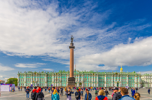 Saint Petersburg, Russia, August 3, 2019: The State Hermitage Museum building, The Winter Palace official residence of the Russian Emperors, Alexander Column and people are walking on Palace Square