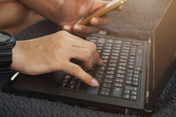 istock Man's hand are keying information from Smartphone into laptop. Identity verification code 1269498394