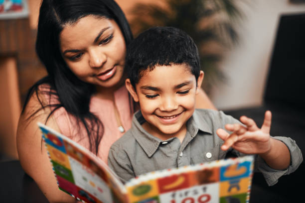 iluminando su mundo con libros - child reading mother book fotografías e imágenes de stock