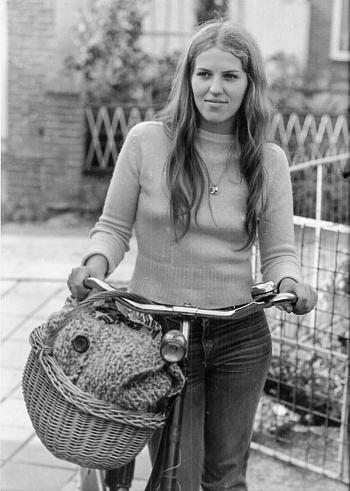 Black and whit retro picture of a young woman with here old bicycle back in the seventies