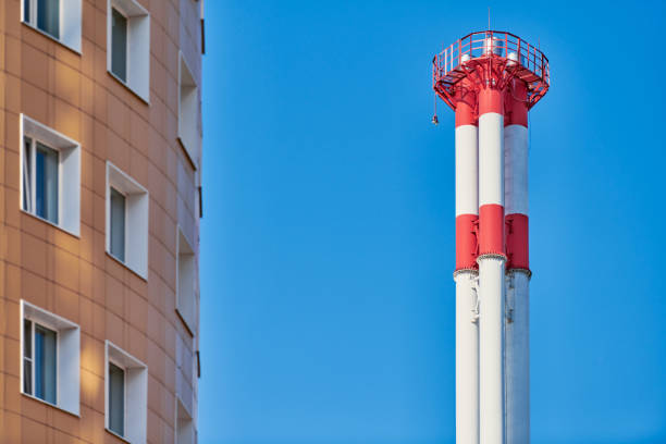 istock Multistorey building facade and factory chimney. 1269508548