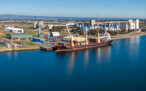istock Aerial view, general cargo ship loading/unloading in river port with city background 1269509524