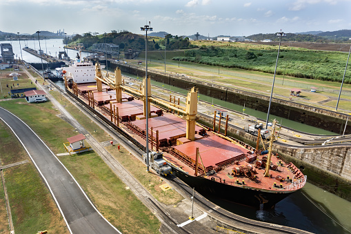 Cargo ship transiting through the Panama Canal. The Panama Canal was built in 1914 and connects the Pacific and Atlantic Oceans. Approximately 14,000 ships transit the canal annually.