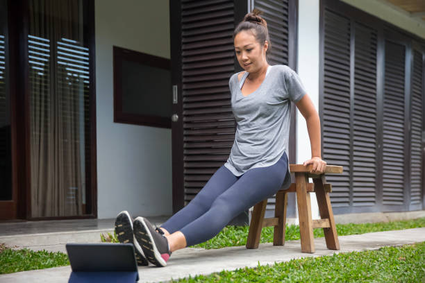 istock Asian woman doing bench dips exercise outside her house using a wooden stool 1269509880