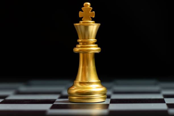 ゴールドキングチェスピースは黒の背景に立っています(リーダーシップのためのコンセプト、ユニーク) - chess king chess chess piece black ストックフォトと画像