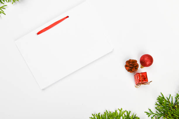 istock notebook with pen on christmas background. Empty white notebook and pen on white Christmas background of fir branches, cones, gifts. Letter To Santa Claus, mock up. Empty white notebook and pen on a white 1269512055