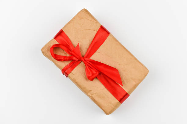istock homemade paper gift wrapping with a red bow on a white background. coniferous green branches on a white background. View from above. Place for writing. Christmas background 1269515876