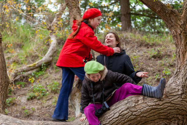 istock Mother with girls spending time together, climbing a giant tree 1269515893