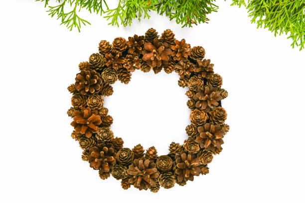 Handmade wreath of cones on a white background. decorated with needles to the side. Handwork. preparing for christmas. place for writing. View from above. Christmas wreath with fir cones on white background. Top View