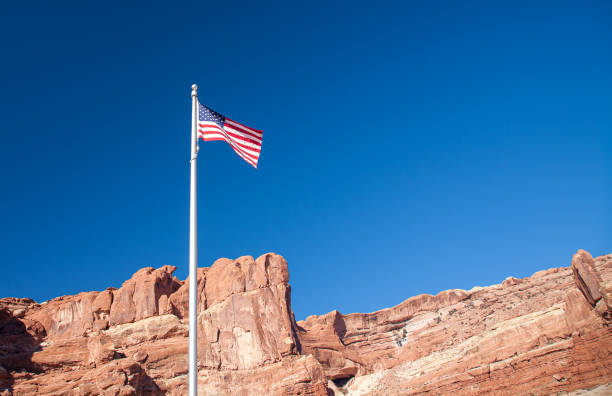 istock US flag with red rocks in background 1269516952