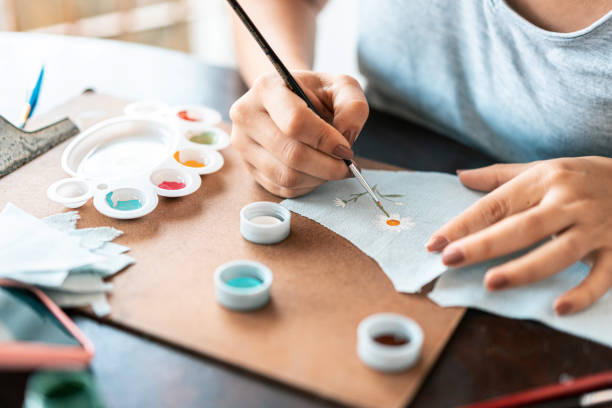 Close-up of hands painting fabric