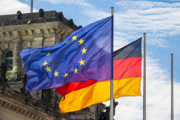 EU and German flags fly in the wind in front of the Reichstag in Berlin Flag of Germany and the European Union in Berlin. State symbol and national government flag of the Federal Republic of Germany and EU. german flag photos stock pictures, royalty-free photos & images