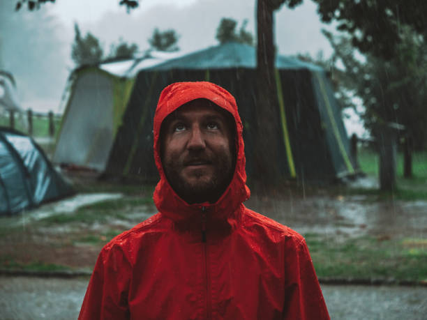 istock Portrait of man caught in a rainstorm while camping 1269521766