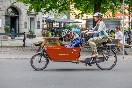 Copenhagen, Denmark, August 5, 2020: Mother and child on a cargo bike in the center of the Danish capital