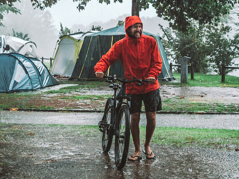 Man camping with bike on rainy day
