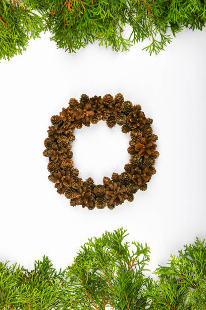istock Handmade wreath of cones on a white background. decorated with needles to the side. Handwork. preparing for christmas. place for writing. View from above. Christmas wreath with fir cones on white background. Top View 1269524758
