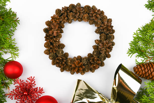 istock Handmade wreath of cones on a white background. decorated with needles to the side. Handwork. preparing for christmas. place for writing. View from above. Christmas wreath with fir cones on white background. Top View 1269524922