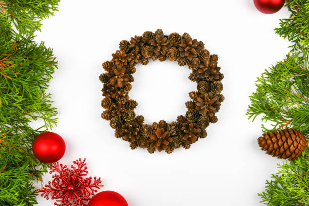 istock Handmade wreath of cones on a white background. decorated with needles to the side. Handwork. preparing for christmas. place for writing. View from above. Christmas wreath with fir cones on white background. Top View 1269526027