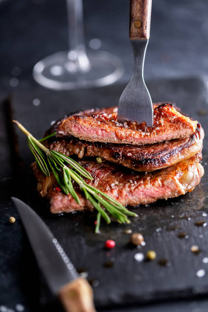 istock Beef Steak on a dark plate with rosemary and pepper 1269526355