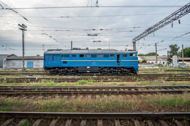 青いシャント機関車が工業地帯を通って乗ります。 - diesel locomotive ストックフォトと画像