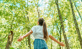 istock Free woman breathing clean air in nature forest. Happy girl from the back with open arms in happiness. Fresh outdoor woods, wellness healthy lifestyle concept. 1269532812