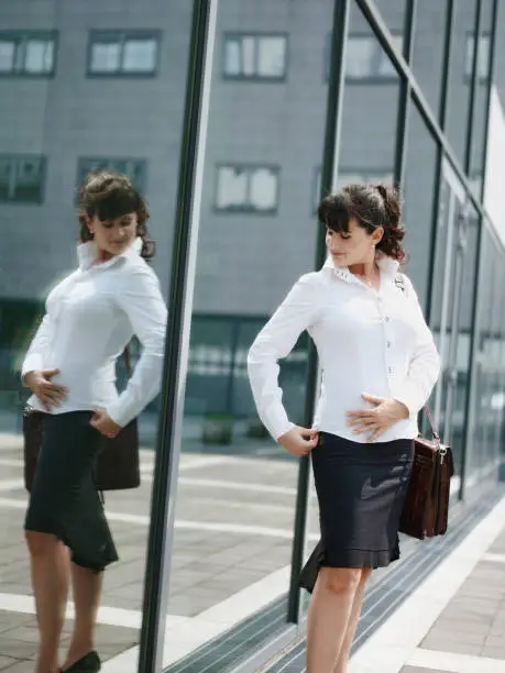 Photo of Mature Woman Losing Weight And Looking At Mirror In Office Window