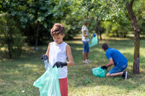istock Child with rubber glasses picking up litter 1269544446