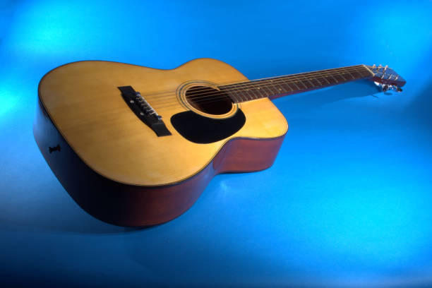 istock Acoustic guitar on a blue background 1269546037