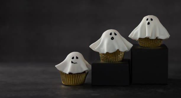 istock Halloween fondant ghost cupcakes on black podiums. 1269547886