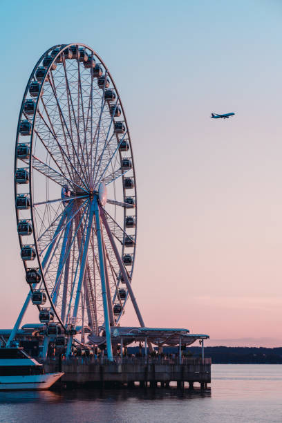 The wheel and the dock in the dusk, with cruise ships and tourists