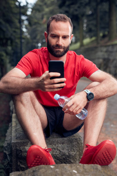 istock Modern sporty man using cellphone after jogging / exercising in the park. 1269550944