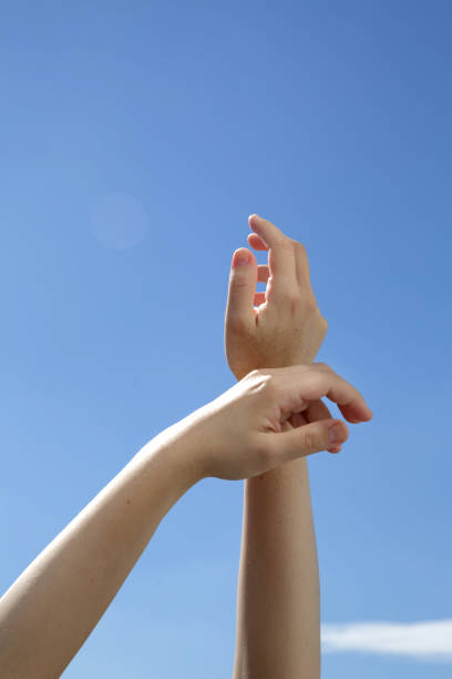 istock Closeup Female hands raised on the blue background 1269553224