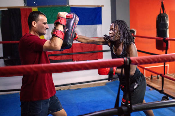 istock Female kick-boxer practising with her coach in a gym 1269555917