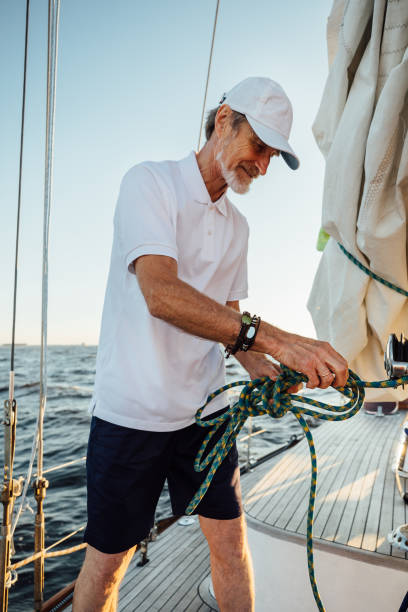 istock Mature yachtsman adjusting the rope tuning on a sunny day 1269555989