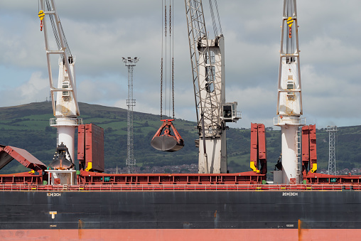 Bulk coal carrier at a commercial dock within Belfast Harbour unloading its cargo.  Belfast, Northern Ireland.
