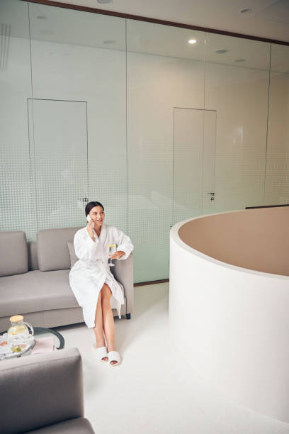 istock Smiling woman sitting with a beverage on the sofa 1269557987