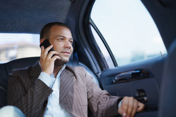 Businessman Talking On Mobile Phone Travelling In Limousine