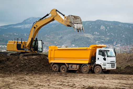 An excavator loading a dumper truck on mining site.