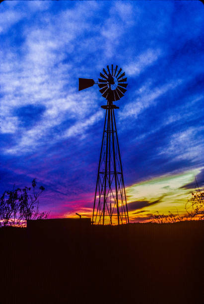 istock Old metal Texas windmill with cistern silhouetted in dramatic sky sunset 1269568096