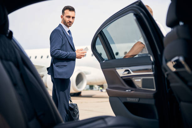 istock Successful businessman standing by the car looking determined 1269570279
