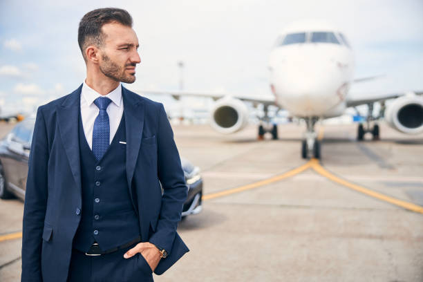 istock Young businessman posing in front of a plane 1269570314