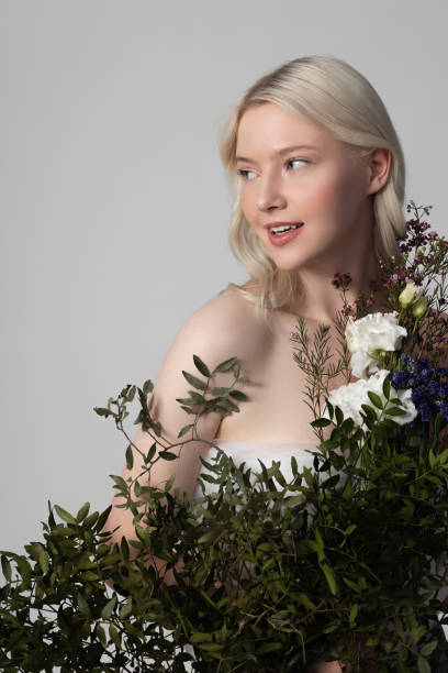 istock Charming young woman standing behind beautiful flowers 1269572437