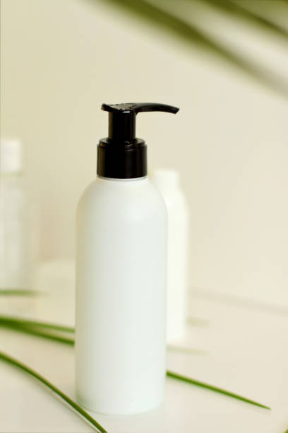 istock White plastic jar with green leaves on background 1269572617