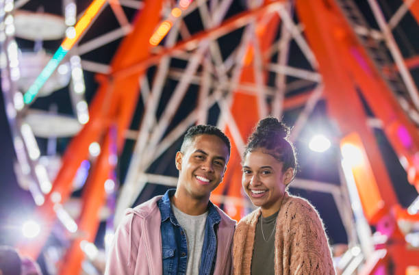 istock Young couple at county fair, by ferris wheel 1269573178