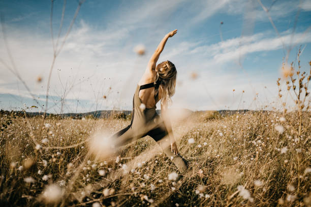 belle femme faisant le yoga dans la nature - moss side photos et images de collection