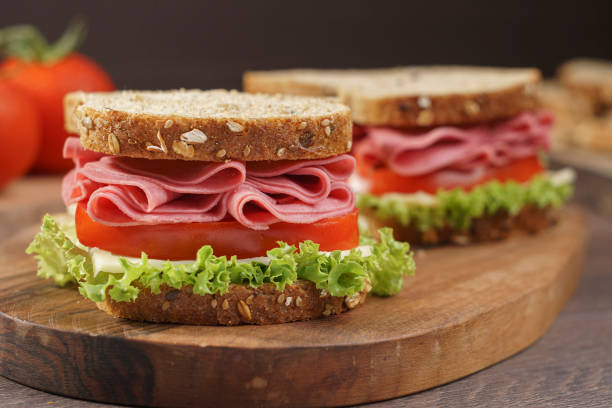istock Whole grain bread sandwich with salami, tomato, cheese and fresh lettuce 1269580406